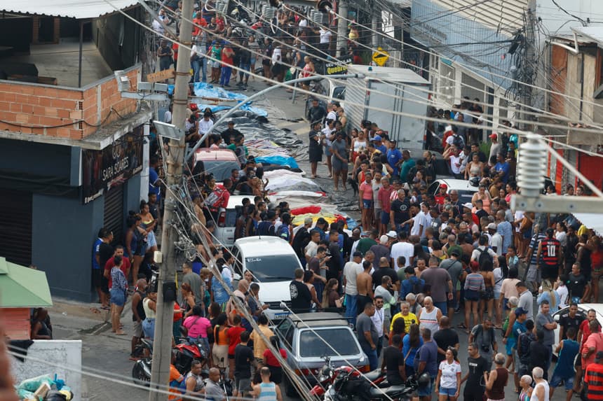 Personas observan cuerpos sin vida en una calle este miércoles, en Río de Janeiro, Brasil. (EFE/ Antonio Lacerda)