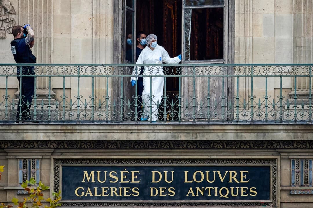 Un oficial forense francés examina una ventana rota en el balcón de la escena del crimen en el Louvre de París el 19 de octubre de 2025. (Kiran Ridley/Getty Images).