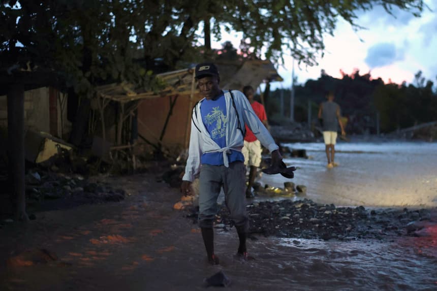Una persona fue captada este miércoles, 29 de octubre, al caminar sobre el lodo tras la creciente del río La Digue, provocada tras el paso del huracán Melissa, en Petit Goave, Haití. (EFE/Mentor David Lorens)