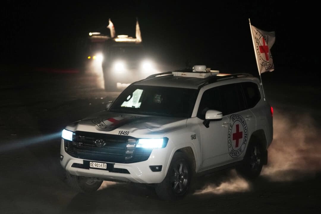 Vehículos de la Cruz Roja que transportan los cadáveres de tres personas que se cree que son rehenes fallecidos, entregados por Hamás, se dirigen hacia el paso fronterizo con Israel, para ser transferidos a las autoridades israelíes, en Deir al-Balah, en el centro de la Franja de Gaza, el 2 de noviembre de 2025. (Jehad Alshrafi/AP Photo).