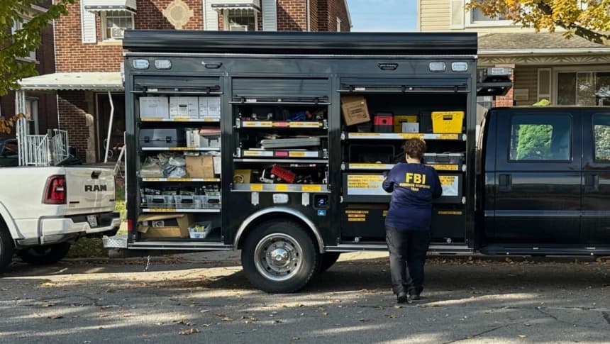 Una agente del FBI se encuentra junto a una camioneta del Equipo de Respuesta a la Evidencia frente a una casa en un barrio de Dearborn, Michigan, el 31 de octubre de 2025. (Mike Householder/AP)