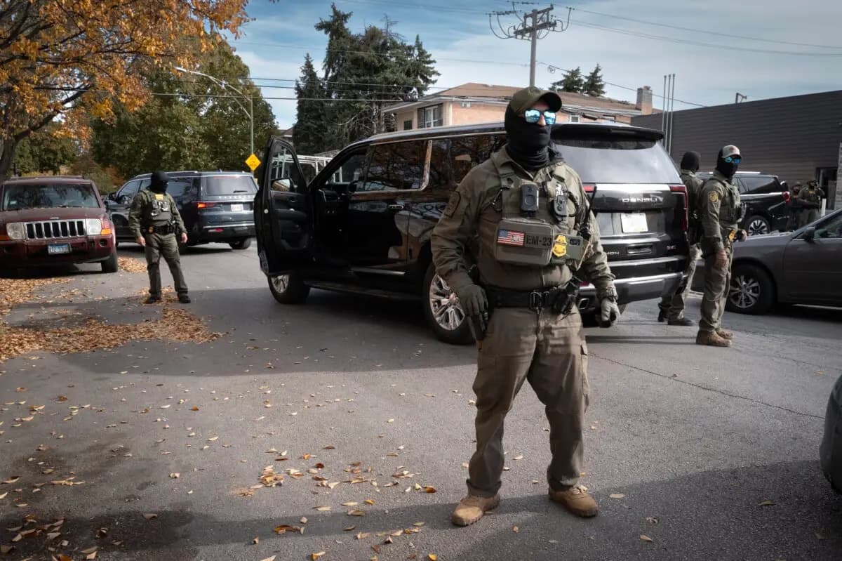 Agentes federales montan guardia mientras son increpados por residentes tras detener una caravana que circulaba por el barrio de Brighton Park en Chicago el 6 de noviembre de 2025. (Scott Olson/Getty Images)