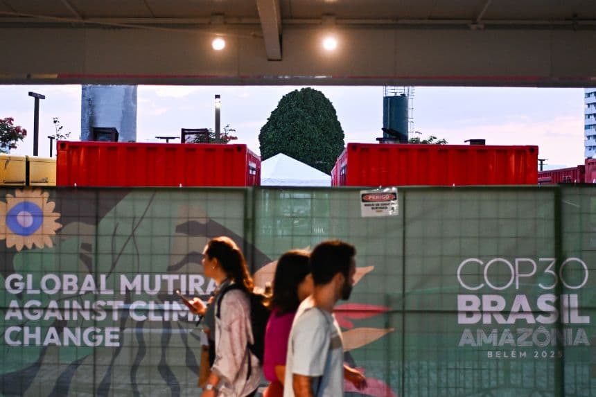 Personas caminan junto a generadores eléctricos que funcionan con diésel a las afueras del Centro de Convenciones Hangar donde se realiza la COP30, este lunes 17 de noviembre de 2025 en Belém, Brasil. (EFE/ Andre Borges)