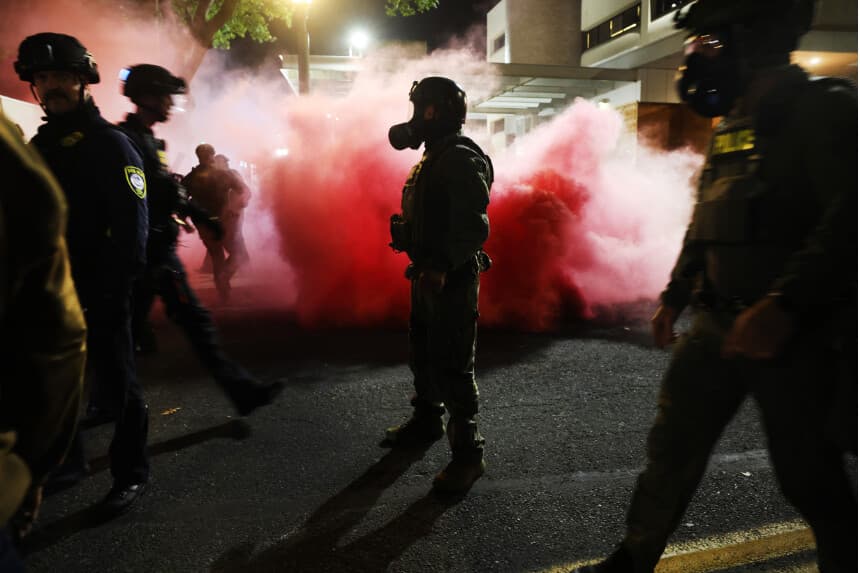 Agentes federales, entre ellos miembros del Departamento de Seguridad Nacional, la Patrulla Fronteriza y la policía, intentan contener a los manifestantes frente a las instalaciones del Servicio de Inmigración y Control de Aduanas (ICE) en el centro de la ciudad, el 5 de octubre de 2025 en Portland, Oregón. (Spencer Platt/Getty Images)