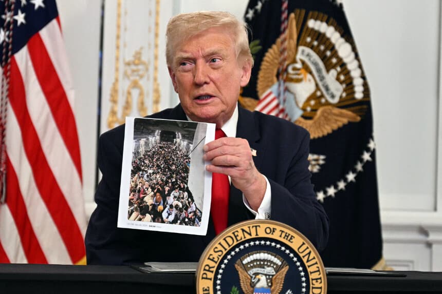 El presidente de Estados Unidos, Donald Trump, muestra una foto impresa durante una llamada con miembros del ejército desde su residencia Mar-a-Lago en Palm Beach, Florida, el 27 de noviembre de 2025, durante las vacaciones de Acción de Gracias. (Foto de Jim WATSON / AFP vía Getty Images)