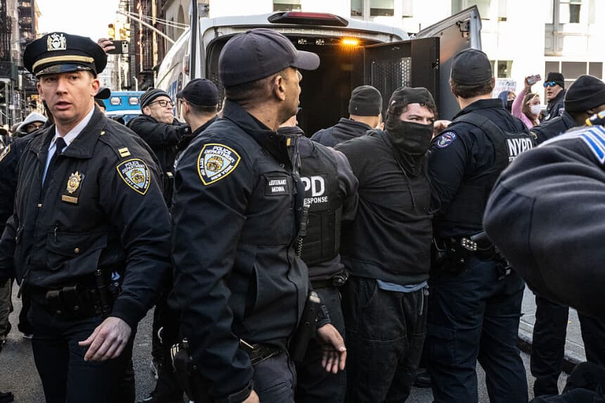 Una persona es detenida por la policía de Nueva York mientras activistas proinmigración bloquean un garaje utilizado por las furgonetas del ICE durante una protesta contra una supuesta redada del ICE en Canal Street, en la ciudad de Nueva York, el 29 de noviembre de 2025. (Stephanie Keith/Getty Images)