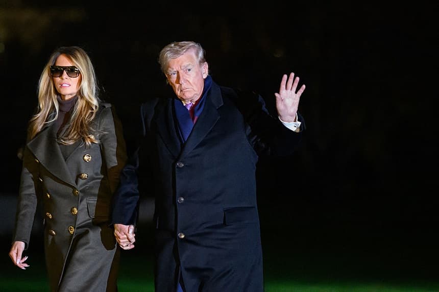 El presidente de Estados Unidos, Donald Trump, acompañado por la primera dama, Melania Trump, saluda a los periodistas tras aterrizar en el Jardín Sur a su llegada a la Casa Blanca en Washington D. C., el 30 de noviembre de 2025. (Mandel NGAN / AFP a través de Getty Images)