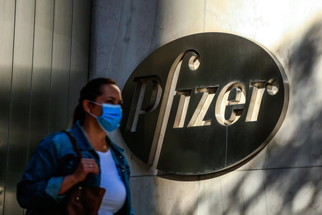 Una mujer usa mascarilla mientras pasa frente a la sede mundial de Pfizer en Nueva York el 9 de noviembre de 2020. Las acciones de Pfizer subieron el 9 de noviembre de 2020 antes de la apertura de Wall Street, tras el anuncio de la compañía de que su vacuna tiene una eficacia del 90 % contra las infecciones por COVID-19. La noticia alegró a los mercados de todo el mundo, especialmente ante el aumento repentino de casos de coronavirus, que obliga a millones de personas a volver al confinamiento. (Foto de KENA BETANCUR/AFP vía Getty Images)
