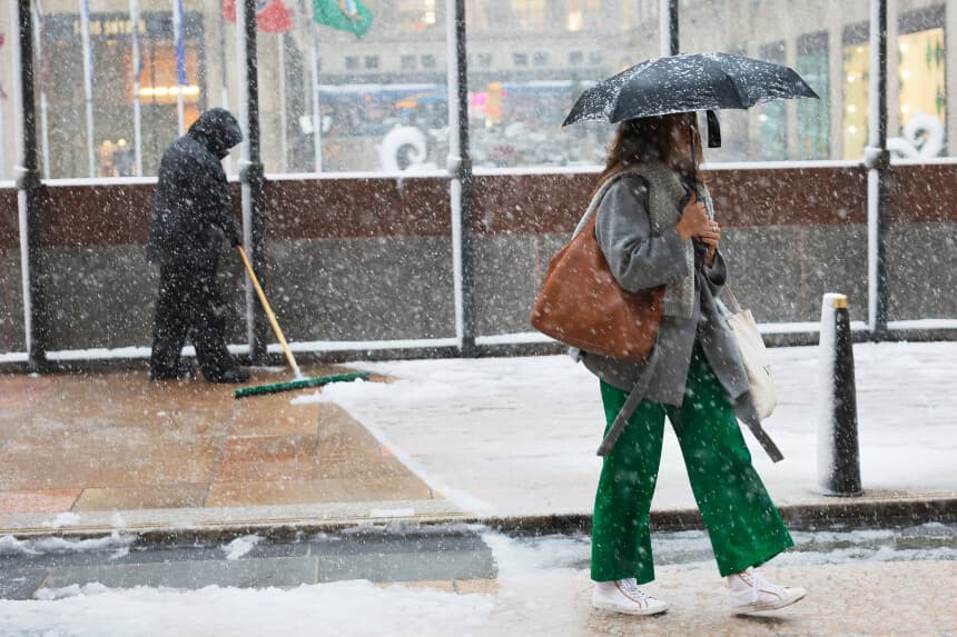 Se retira la nieve de una acera mientras la gente camina por el Rockefeller Center en medio de una tormenta invernal el 13 de febrero de 2024 en la ciudad de Nueva York. (Michael M. Santiago/Getty Images)