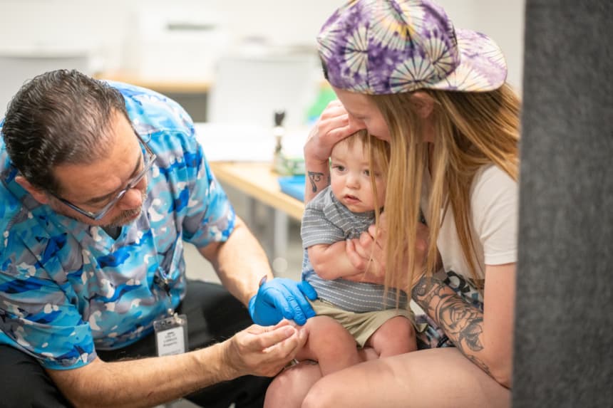 River Jacobs, de un año, es sostenido por su madre, Caitlin Fuller, mientras recibe una vacuna MMR de Raynard Covarrubio, en una clínica de vacunación organizada por el Departamento de Salud Pública de Lubbock el 1 de marzo de 2025 en Lubbock, Texas. (Jan Sonnenmair/Getty Images)