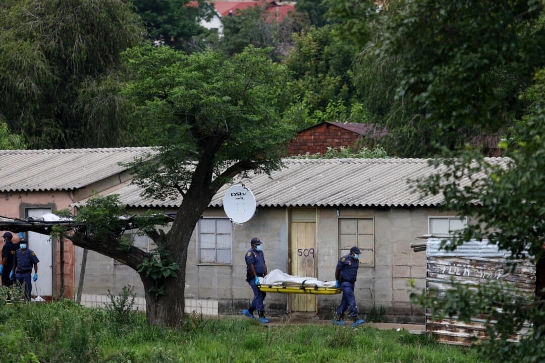 Agentes de policía transportan el cuerpo de una persona en una camilla tras un tiroteo masivo en un bar cerca de Pretoria, Sudáfrica, el 6 de diciembre de 2025. (Foto AP)
