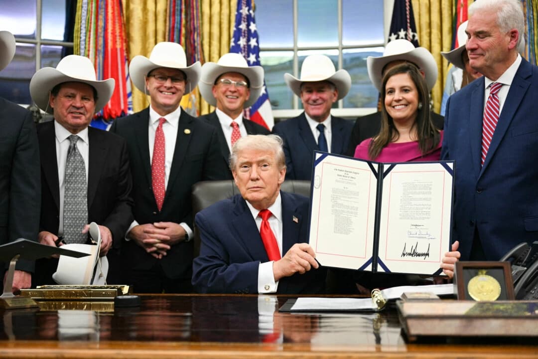 El presidente Donald Trump muestra un proyecto de ley durante una ceremonia con miembros del equipo olímpico de hockey sobre hielo masculino de Estados Unidos de 1980 en la Oficina Oval de la Casa Blanca en Washington el 12 de diciembre de 2025. (Jim Watson/AFP vía Getty Images)