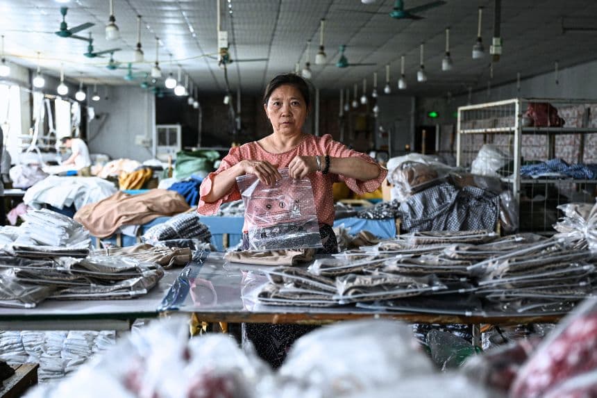 Una empleada empaqueta prendas para la empresa china de comercio electrónico Temu en una fábrica de ropa en Guangzhou, en la provincia de Guangdong, al sur de China, el 16 de abril de 2025. (JADE GAO/AFP a través de Getty Images)