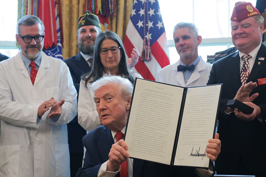 El presidente de Estados Unidos, Donald Trump, muestra una orden ejecutiva que firmó en el Despacho Oval de la Casa Blanca el 18 de diciembre de 2025 en Washington, D.C. Durante la ceremonia, Trump firmó la orden que reclasifica la marihuana como droga de la lista III. (Foto de Anna Moneymaker/Getty Images)