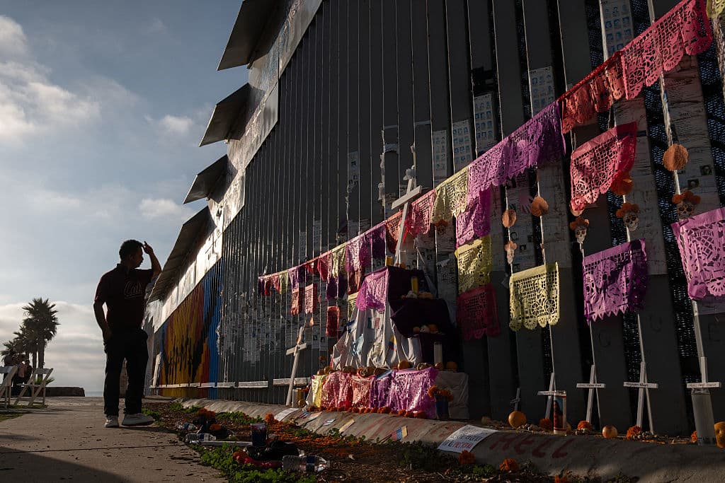 Un hombre observa un altar en honor a los migrantes fallecidos en el muro fronterizo entre México y Estados Unidos durante las celebraciones del Día de Muertos en Playas de Tijuana, estado de Baja California, México, el 1 de noviembre de 2025. (Foto de Guillermo Arias / AFP) (Foto de GUILLERMO ARIAS/AFP a través de Getty Images)