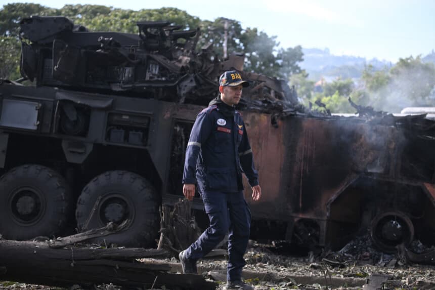 TOPSHOT - Un bombero pasa junto a un vehículo militar quemado en la base aérea de La Carlota, en Caracas, el 3 de enero de 2026, después de que las fuerzas estadounidenses capturaran al líder venezolano Nicolás Maduro tras lanzar un "ataque a gran escala" contra el país sudamericano. (Foto de Federico PARRA / AFP a través de Getty Images)