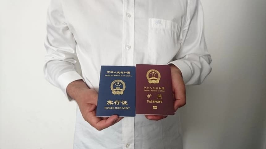 Un ciudadano chino no identificado sostiene su pasaporte chino vencido (rojo) y un documento de viaje de ida (azul) emitido en su lugar por la misión china en Arabia Saudita, en Medina, el 2 de octubre de 2019. (AFP vía Getty Images)