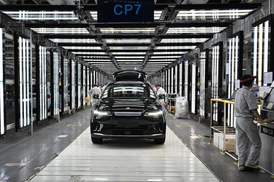 Empleados trabajan en una línea de producción de vehículos eléctricos (EV) en la fábrica de Leapmotor en Jinhua, provincia de Zhejiang, China, el 18 de septiembre de 2024. (Adek Berry/AFP a través de Getty Images)