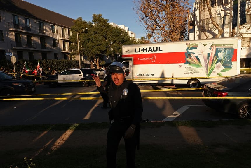 Personas caminan cerca de un camión de mudanzas que, según informes, fue conducido contra una multitud durante una manifestación contra el régimen iraní en Los Ángeles, California, el 11 de enero de 2026. (Jonathan Alcorn/AFP vía Getty Images)