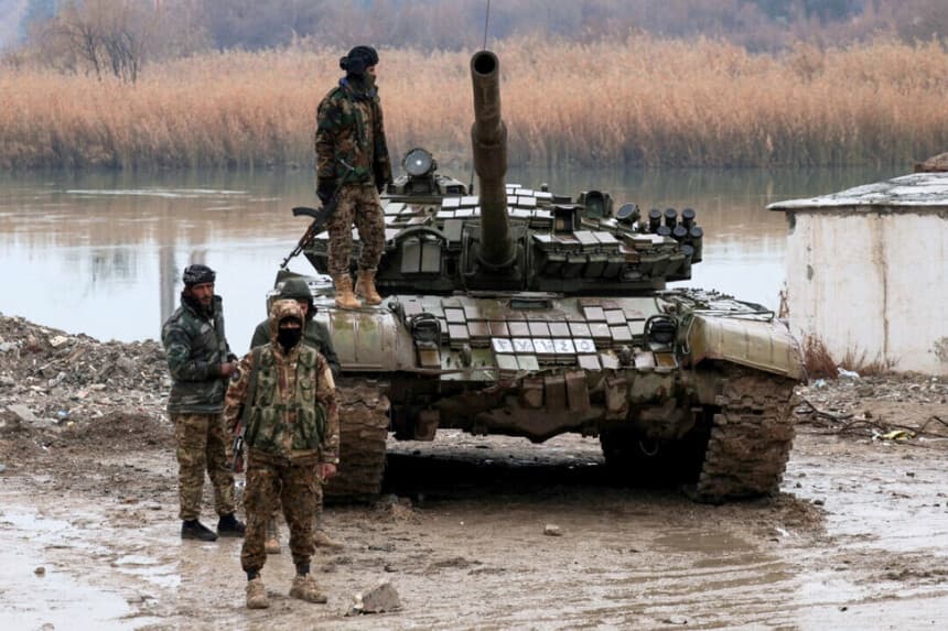 Personal militar se encuentra en el cruce que conecta las dos orillas del río Éufrates, mientras otras personas intentan cruzar al otro lado después de que las Fuerzas Democráticas Sirias (SDF) se retiraran de la provincia de Deir al-Zor y el ejército sirio tomara el control total de la zona, en Deir al-Zor, Siria, el 18 de enero de 2026. (Khalil Ashawi/Reuters).