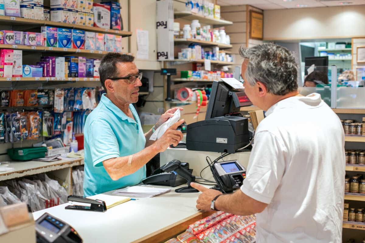 Un farmacéutico ayuda a un hombre con sus medicamentos recetados en una farmacia de Nueva York el 18 de junio de 2014. (The Epoch Times).