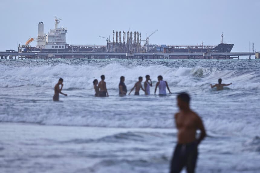 PUERTO CABELLO, VENEZUELA - 18 DE DICIEMBRE: La gente se baña en el mar mientras se ve un petrolero anclado en el muelle a las afueras de la refinería "El Palito" el 18 de diciembre de 2025 en Puerto Cabello, Venezuela. El presidente Trump declaró el 17 de diciembre que Venezuela le quitó los derechos petroleros a Estados Unidos. La administración de Trump ha sancionado al petróleo venezolano con bloqueos, mientras que muchas unidades de la Marina de Estados Unidos están desplegadas frente a las costas de Venezuela con la premisa de combatir los cárteles de la droga. (Foto de Jesús Vargas/Getty Images).