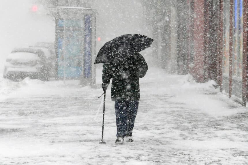 Un peatón con un paraguas cruza la calle en Harlem durante una tormenta de nieve el 4 de enero de 2018 en la ciudad de Nueva York. A medida que una gran tormenta invernal avanza por el corredor noreste, la ciudad de Nueva York se encuentra bajo una alerta de tormenta invernal y las previsiones anuncian entre 15 y 20 centímetros de nieve. (Dipasupil/Getty Images)