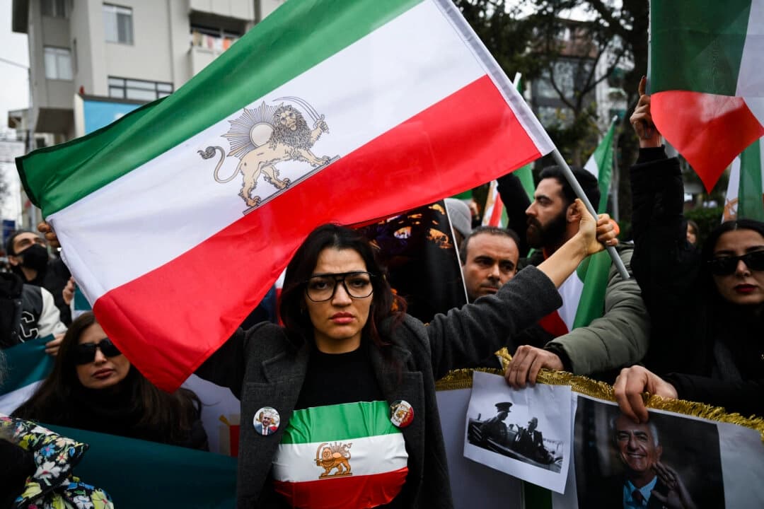 Un manifestante contra el régimen iraní sostiene una bandera de Irán anterior a la revolución de 1979, con los emblemas del león y el sol, durante una manifestación en solidaridad con los manifestantes iraníes y en contra de la República Islámica por matar a ciudadanos iraníes, en Yalova, Turquía, el 16 de enero de 2026. (Yasin Akgul/AFP vía Getty Images)