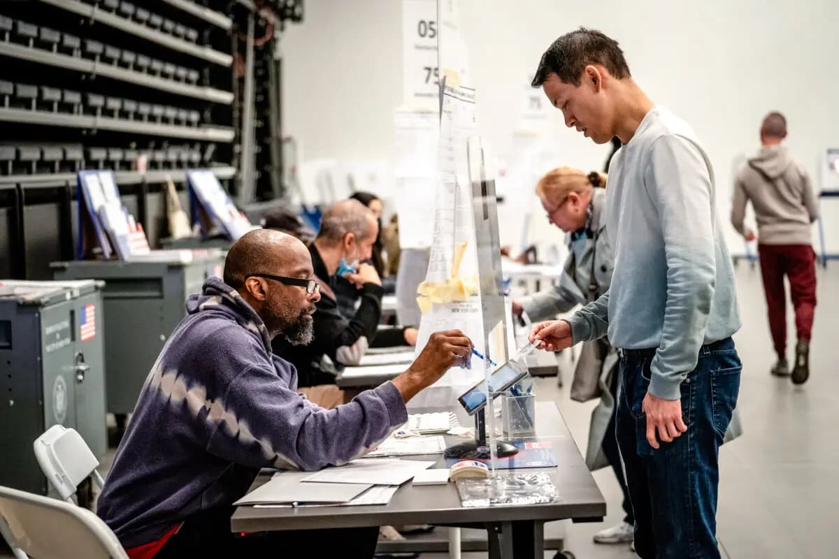 Un votante muestra su identificación con fotografía a los trabajadores electorales al llegar para emitir su voto en las elecciones de mitad de mandato en la ciudad de Nueva York el 8 de noviembre de 2022. (Samira Bouaou/The Epoch Times)