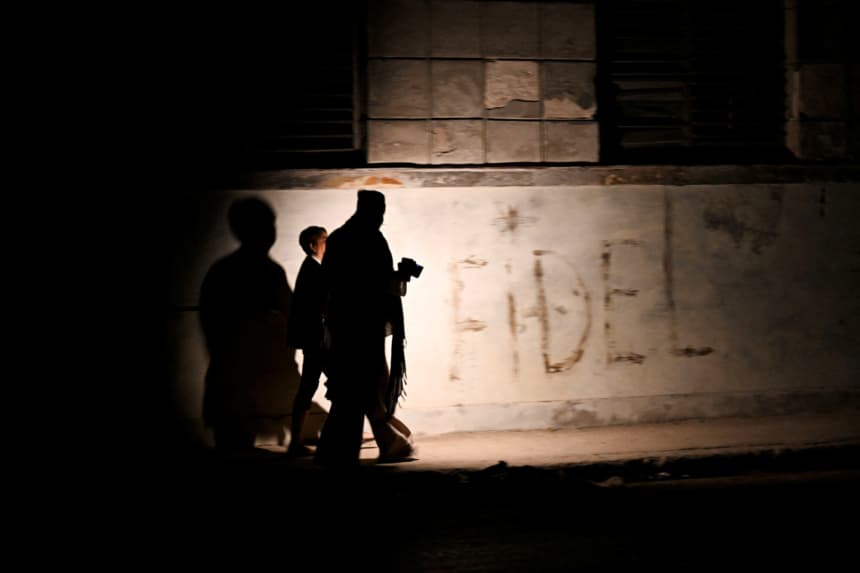 Imagen ilustrativa: Varios cubanos caminan por una calle durante un apagón general en La Habana, el 14 de marzo de 2025. Cuba sufrió otro apagón generalizado el 14 de marzo de 2025, provocado por una falla en su sistema eléctrico nacional, según informó el Ministerio de Energía y Minas. (YAMIL LAGE/AFP via Getty Images)