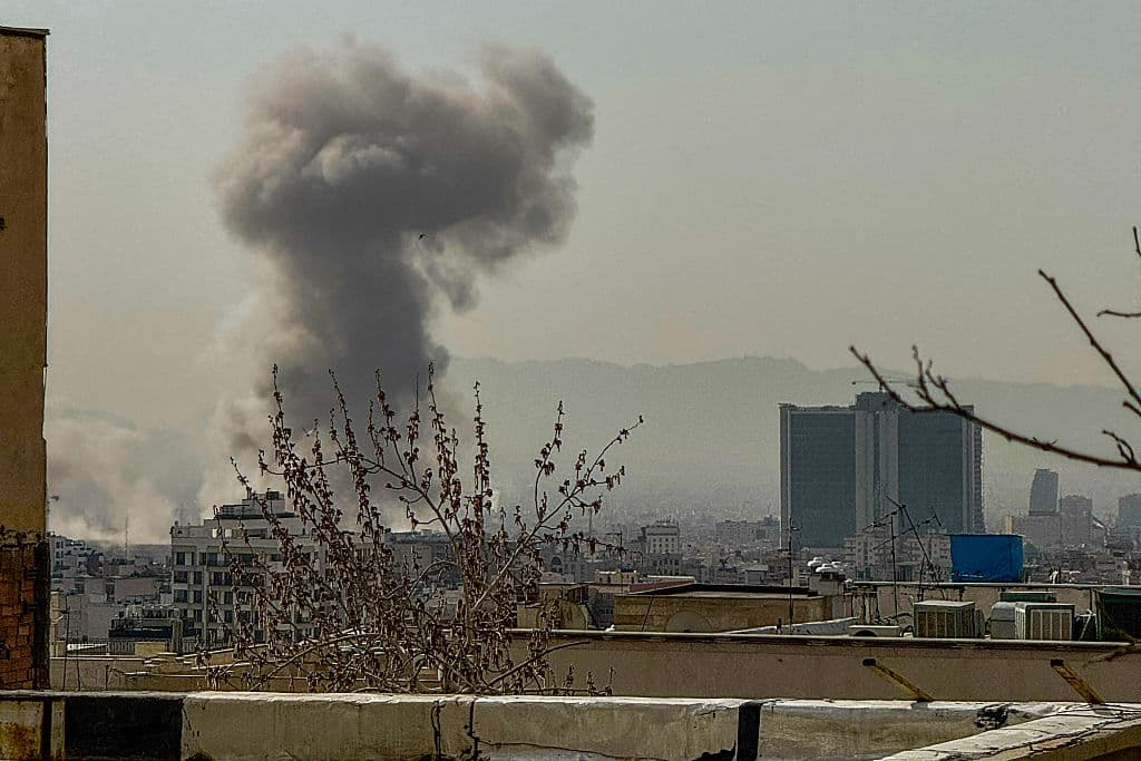 A plume of smoke rises over Tehran after a reported explosion on February 28, 2026, after Israel said it carried out a "preemptive strike" on Iran as sirens sounded in Jerusalem and phone alerts warned of an "extremely serious" threat. (Photo by Mahsa / Middle East Images / AFP via Getty Images)