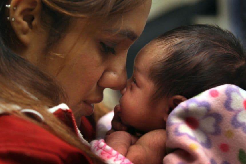 Imagen ilustrativa: Madre sostiene a su recién nacida durante un chequeo de salud. (John Moore/Getty Images)