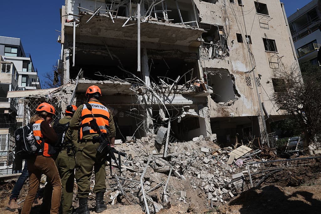 Personal de los servicios de emergencia israelíes se reúne en el lugar de un ataque con misiles iraníes en Tel Aviv el 24 de marzo de 2026. (Foto de Jack GUEZ / AFP vía Getty Images) /