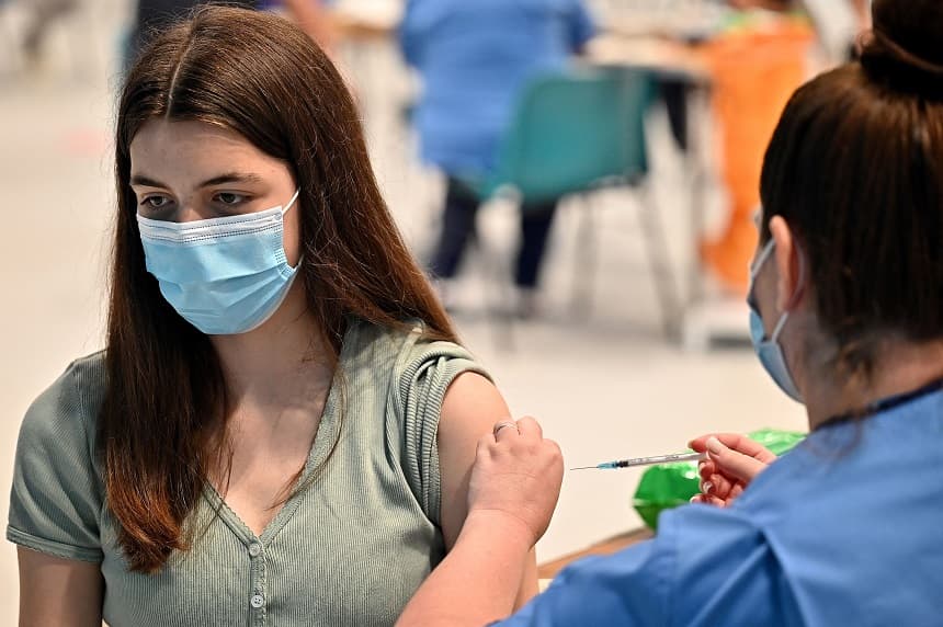 La adolescente Katie Moore recibe la vacuna contra el COVID-19 en un centro de vacunación en Barrhead, al sur de Glasgow, el 9 de agosto de 2021. (JEFF J MITCHELL/POOL/AFP vía Getty Images)