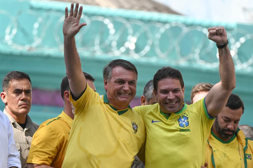 El expresidente brasileño Jair Bolsonaro (izquierda) y el congresista Alexandre Ramagem saludan a la multitud durante un mitin en apoyo a la candidatura de este último a la alcaldía de Río de Janeiro en las próximas elecciones municipales, celebrado en Río de Janeiro, Brasil, el 18 de julio de 2024. (MAURO PIMENTEL/AFP vía Getty Images).