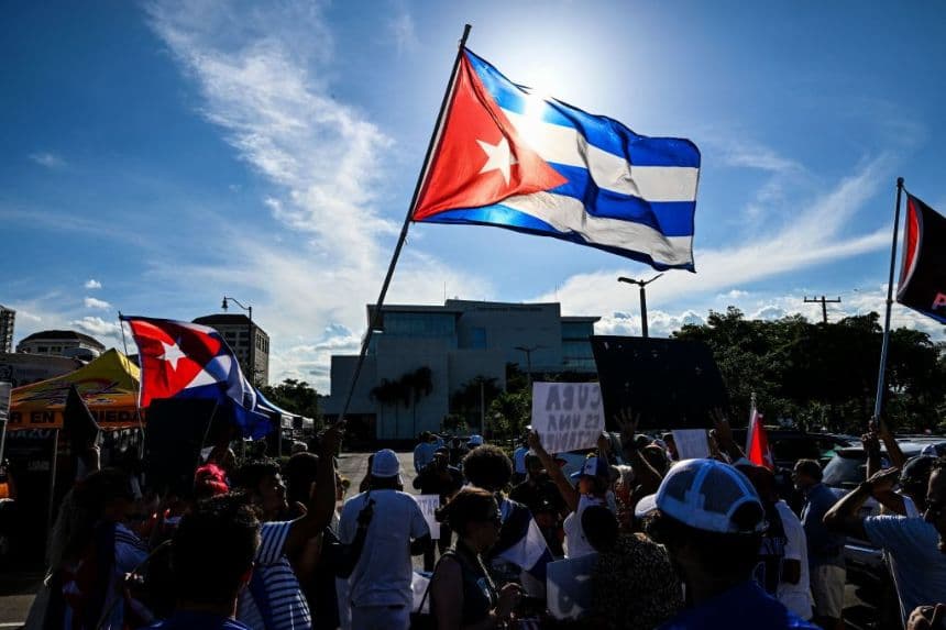 La gente ondea una bandera cubana mientras desfila por las calles de Miami, Florida, para conmemorar las históricas protestas del año anterior en Cuba, el 11 de julio de 2022. (CHANDAN KHANNA/AFP vía Getty Images)