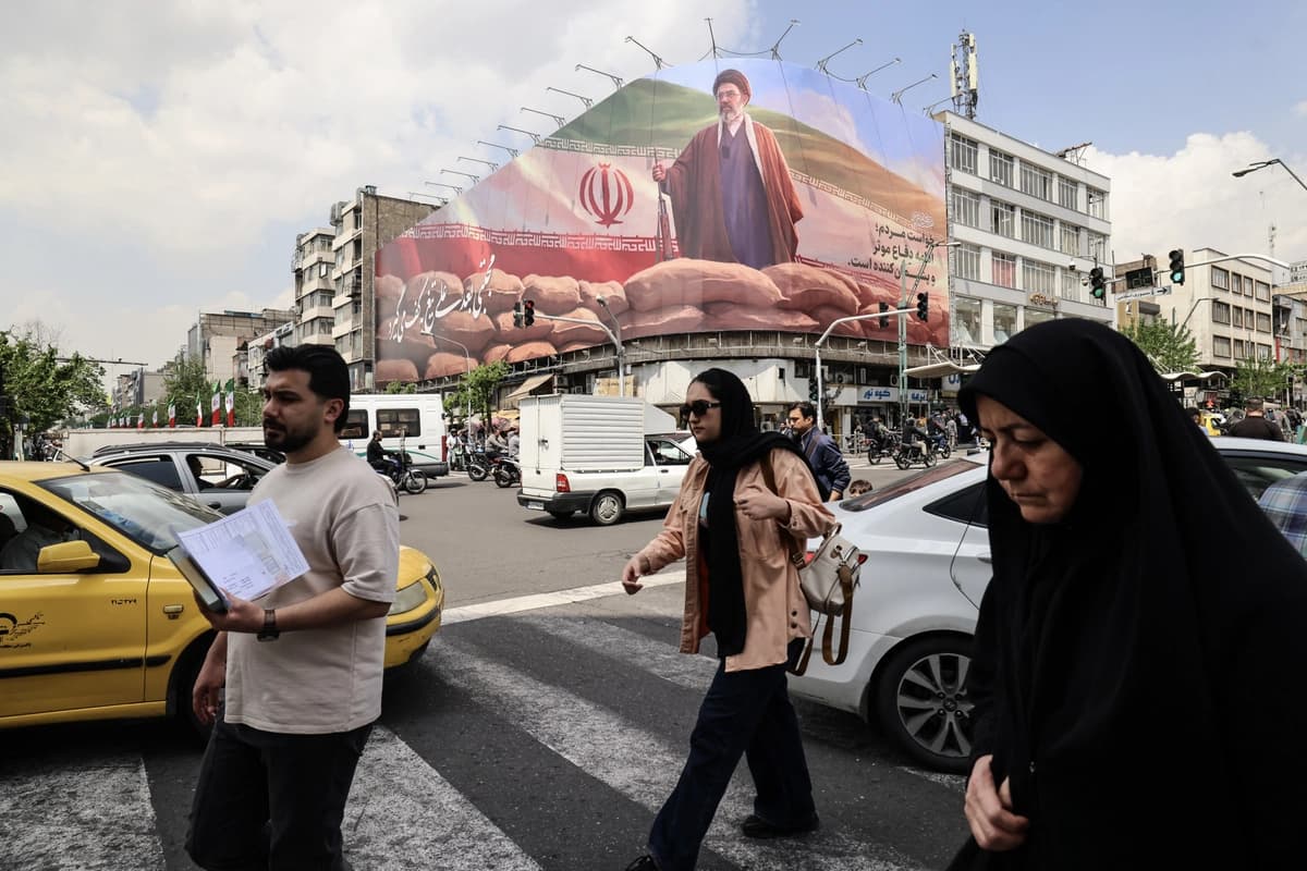 Iraníes caminan en una calle con una gran valla publicitaria que muestra al líder iraní, el ayatolá Mojtaba Khamenei, en Teherán el 20 de abril de 2026. (Atta Kenare/AFP vía Getty Images)