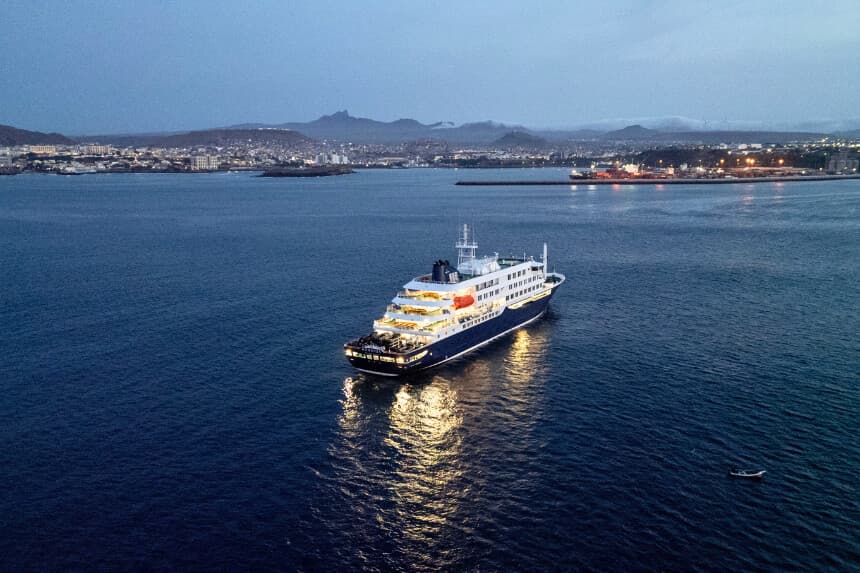 Vista general del crucero MV Hondius, atracado frente al puerto de Praia, capital de Cabo Verde, el 6 de mayo de 2026. Dos tripulantes gravemente enfermos de un crucero afectado por un brote mortal de hantavirus serán evacuados a través de Cabo Verde hacia los Países Bajos, lo que permitirá al buque proseguir su travesía hacia las Islas Canarias, según informó la compañía naviera el 5 de mayo de 2026. El MV Hondius ha sido el centro de una alarma sanitaria internacional desde el sábado, cuando se informó a la OMS de que se sospechaba que esta rara enfermedad —que suele transmitirse a partir de roedores infectados, normalmente a través de la orina, los excrementos y la saliva— era la causa de la muerte de tres de sus pasajeros. A medida que otros caían enfermos, los pasajeros y la tripulación han permanecido en aislamiento después de que las autoridades de Cabo Verde prohibieran al buque atracar, y mientras las autoridades sanitarias se apresuraban a encontrar un puerto que acogiera al Hondius. (Foto de AFP vía Getty Images).