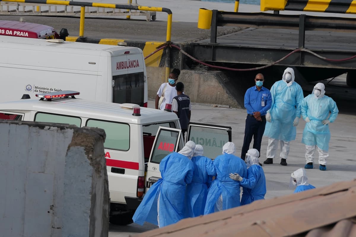 Trabajadores de la salud con equipo de protección evacuan a pacientes del crucero MV Hondius a una ambulancia en un puerto de Praia, Cabo Verde, el 6 de mayo de 2026. (Foto de Misper Apawu/AP)