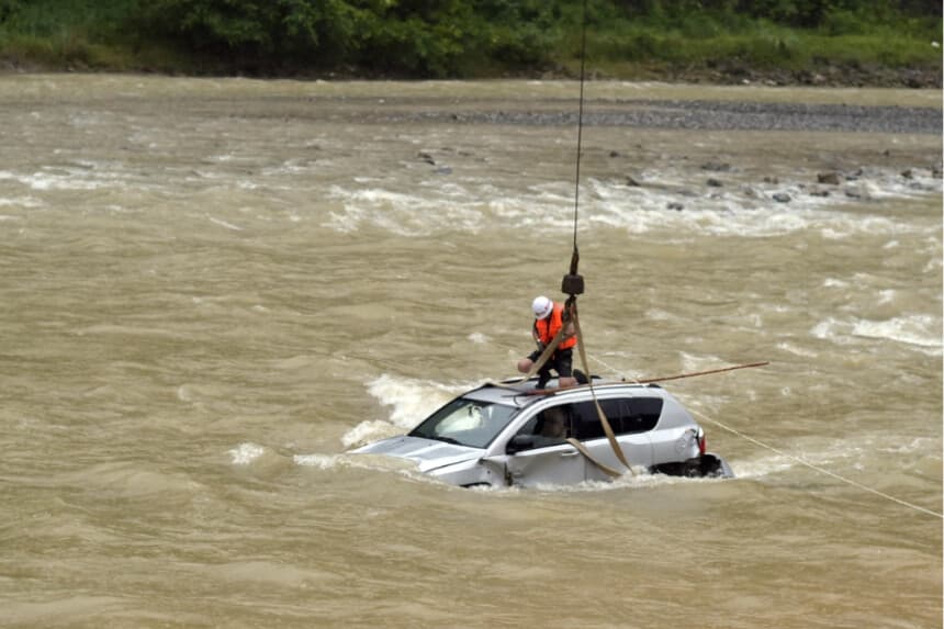 Un bombero traslada un automóvil atrapado en una inundación con la ayuda de una grúa en el condado de Wuxi, en Chongqing, China, el 14 de julio de 2015. (Getty Images).