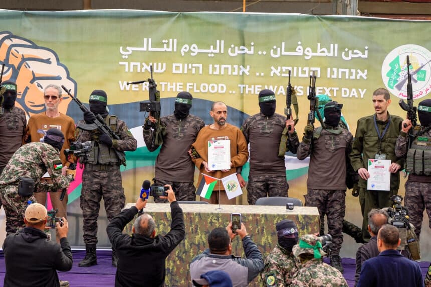 Los rehenes israelíes que han permanecido cautivos en manos de Hamás en Gaza desde el 7 de octubre de 2023 aparecen escoltados por terroristas de Hamás en un escenario antes de ser entregados a la Cruz Roja en Deir al-Balah, en el centro de la Franja de Gaza, el 8 de febrero de 2025. (Foto de AP/Abdel Kareem Hana).