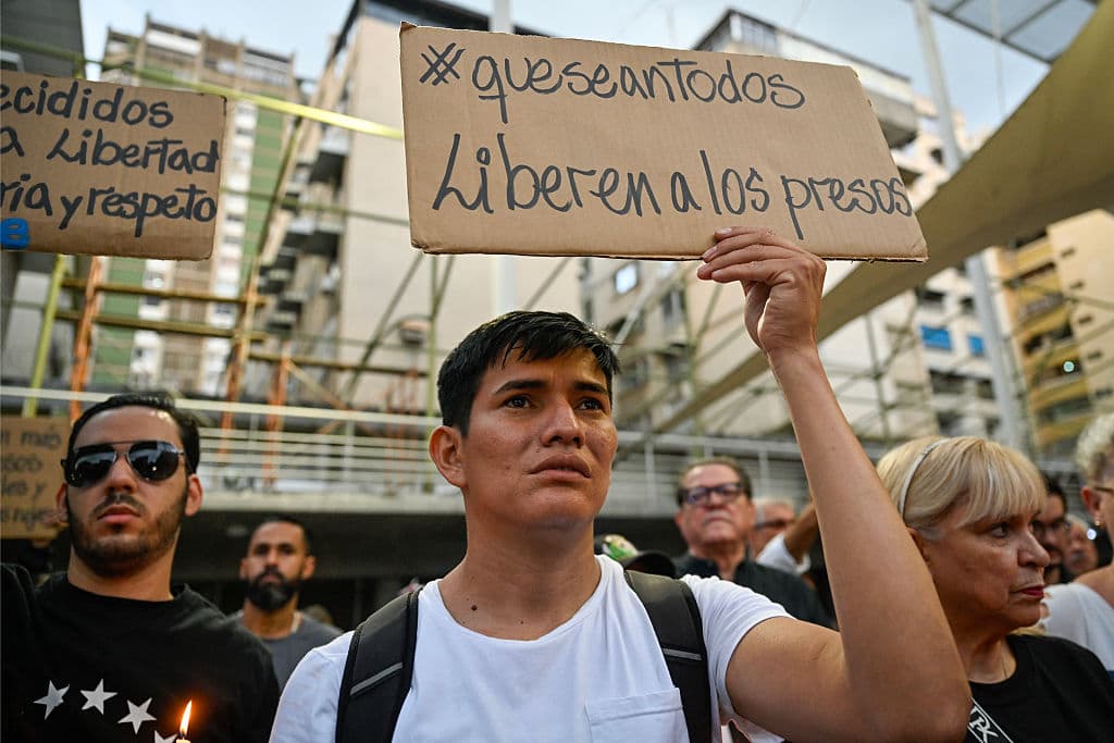 Una persona sostiene un cartel que dice "Liberen a los presos", durante una vigilia convocada por familiares de presos políticos en Caracas el 22 de mayo de 2026. La presidenta interina de Venezuela, Delcy Rodríguez, dijo el 22 de mayo que la liberación de presos políticos superará los 500 "en las próximas horas", según anunció durante una transmisión oficial. (Foto de Maryorin Méndez / AFP vía Getty Images)