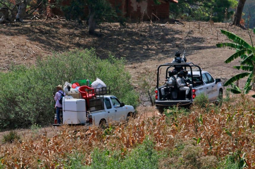 Pobladores son resguardados por integrantes de la Guardia Nacional de México el 18 de mayo, en la zona donde se suscitaron enfrentamientos el pasado 11 de mayo en Chilapa, Guerrero, México. Una semana después del desplazamiento de comunidades indígenas por los ataques armados de grupos del crimen organizado, varias comunidades de Chilapa de Álvarez, Guerrero, lucen abandonadas por el temor de sus habitantes a una nueva ola de violencia a su regreso. (EFE/José Luis De La Cruz)