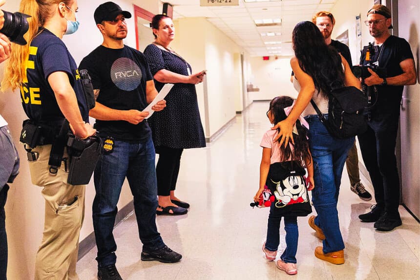 Una mujer y un niño pasan junto a agentes federales mientras estos patrullan los pasillos del tribunal de inmigración en el Edificio Federal Jacob K. Javits el 28 de julio de 2025 en la ciudad de Nueva York. (Michael M. Santiago/Getty Images)