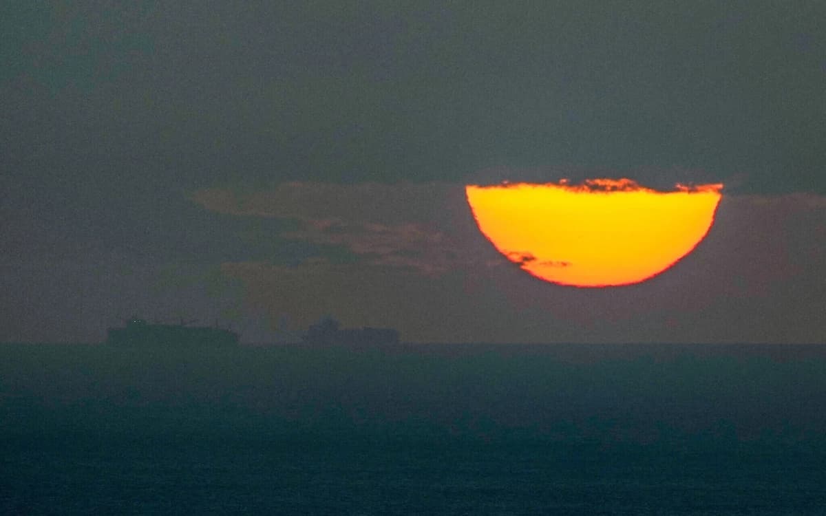 Barcos navegan por el Golfo Arábigo hacia el Estrecho de Ormuz mientras se pone el sol en los Emiratos Árabes Unidos el 23 de marzo de 2026. (Foto AP)