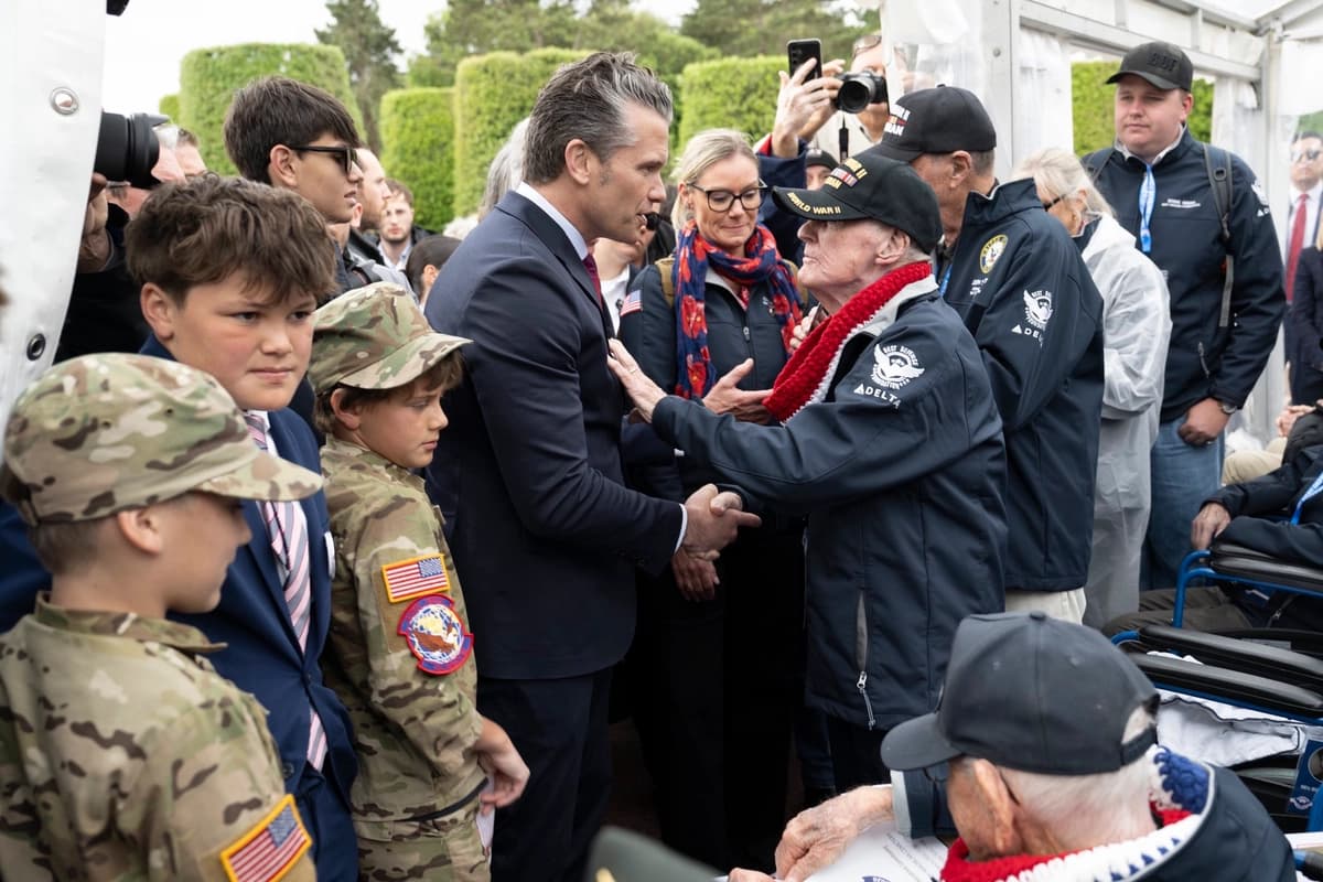 El secretario de Defensa de EE. UU., Pete Hegseth (C), habla con veteranos estadounidenses de la Segunda Guerra Mundial y del Desembarco del Día D en una ceremonia conmemorativa celebrada como parte del 82.º aniversario del desembarco aliado del Día D de la Segunda Guerra Mundial en Normandía, al noroeste de Francia, el 6 de junio de 2026. (Captura de pantalla vía The Epoch Times/X/Departamento de Guerra)