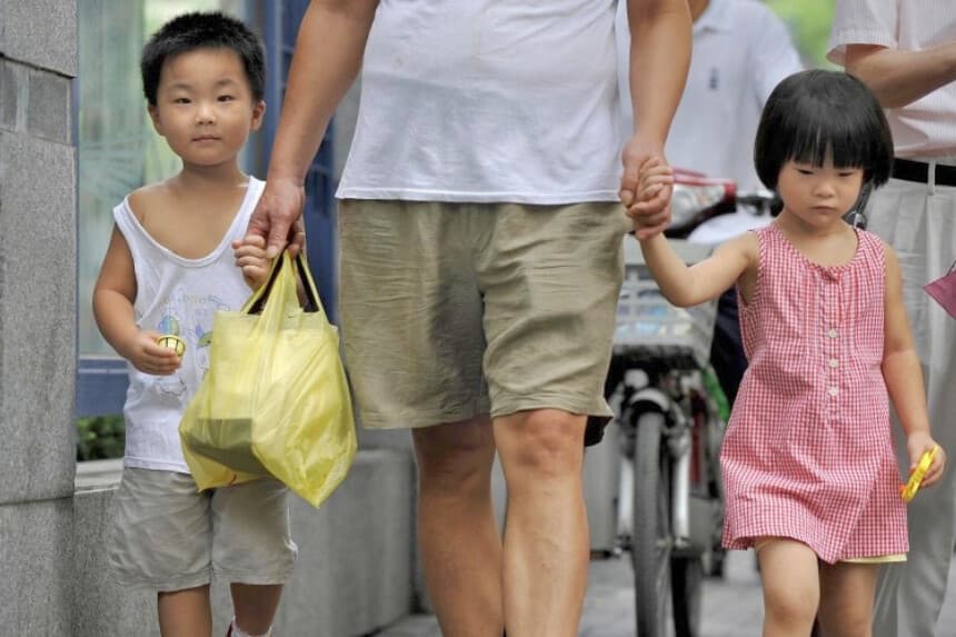 Un hombre y dos niños en Shanghái, en una fotografía de archivo. China se enfrenta a los retos que plantean el envejecimiento de la población, la disminución de la población activa y el desequilibrio de género, consecuencias de treinta años de política de control demográfico. (AFP/Getty Images).