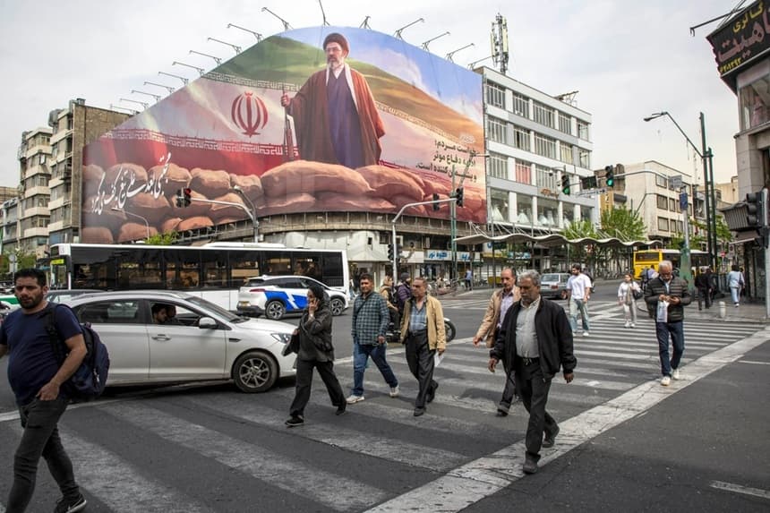 Unos peatones pasan bajo una pancarta en la que aparece Mojtaba Jamenei, el nuevo líder supremo de Irán, en Teherán el 12 de abril de 2026. (Majid Saeedi/Getty Images)