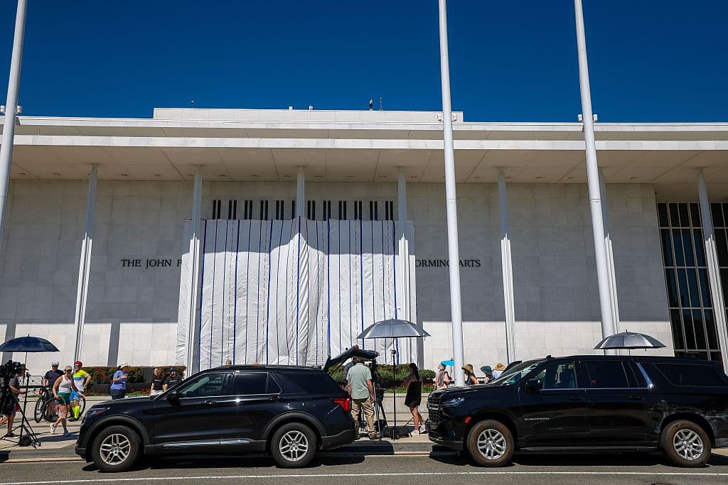La gente y los medios de comunicación se concentran en el exterior mientras se cuelgan lonas en los andamios del Centro Kennedy el 13 de junio de 2026 en Washington, D.C. En la madrugada del viernes, unos trabajadores retiraron el nombre del presidente Donald Trump del Centro Kennedy. (Foto de Tasos Katopodis/Getty Images)