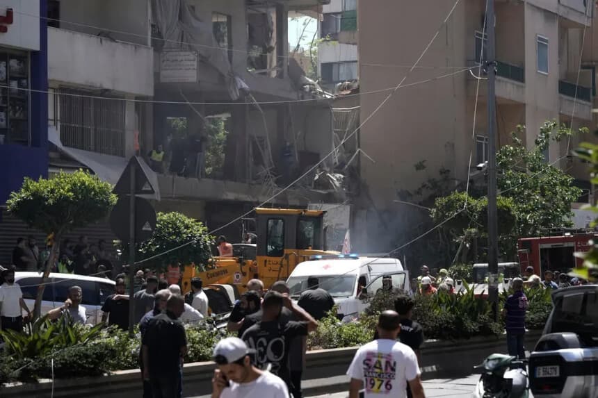 Varias personas se congregan en el lugar donde un ataque aéreo israelí impactó un apartamento en Dahiyeh, en los suburbios del sur de Beirut, Líbano, el 14 de junio de 2026. (Bilal Hussein/AP).
